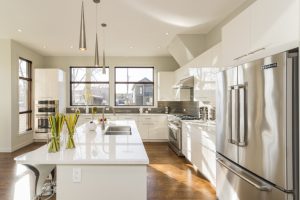 Ambiente de sala e cozinha integradas, com um espaço para sofá, mesa de jantar e um balcão que divide a cozinha.