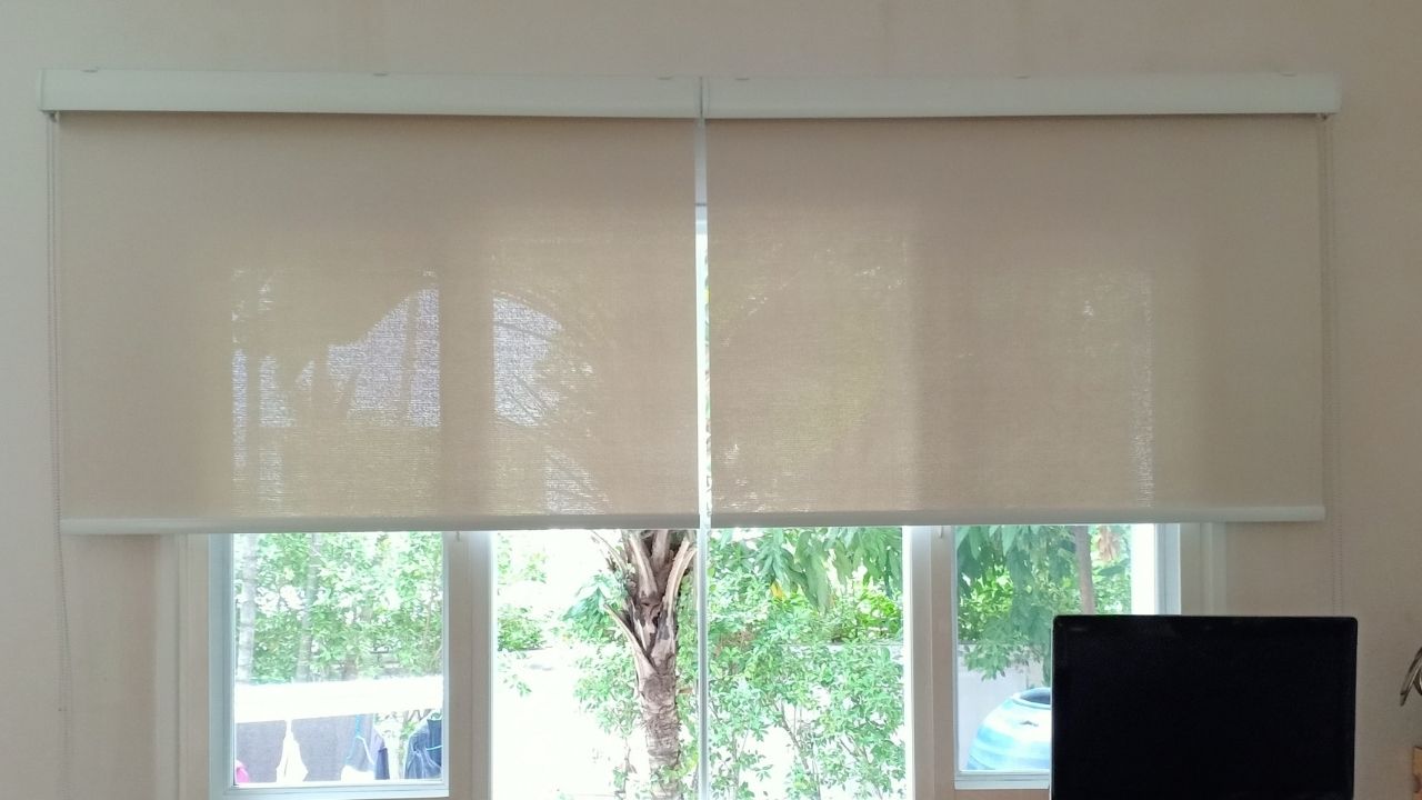 Uma janela com vista para a natureza, com uma persiana instalada.