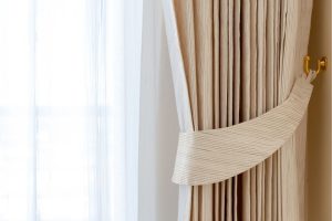 cortina bege com detalhes plissados.