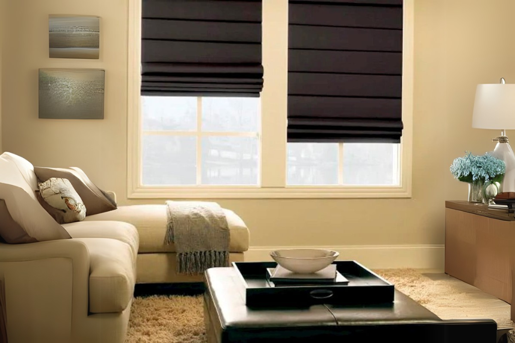 sala de estar com persiana romana blackout preta, sofá-cama com coberta e almofadas, mesa de centro com decoração, luminárias, estante com abajur e flores