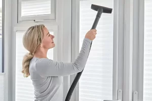 mulher limpando persiana para conservá-la por mais tempo