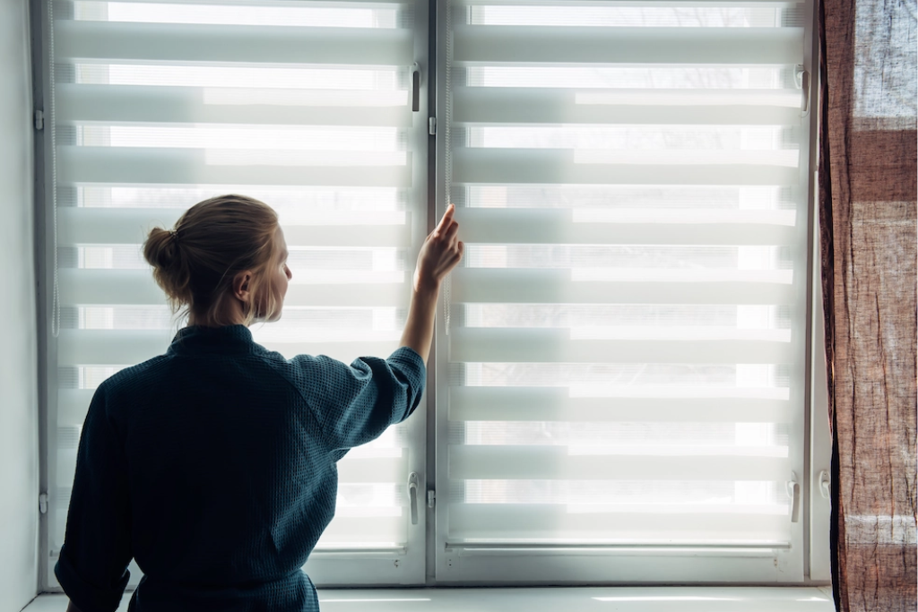 mulher tocando sua persiana double vision, tendência de decoração em 2025