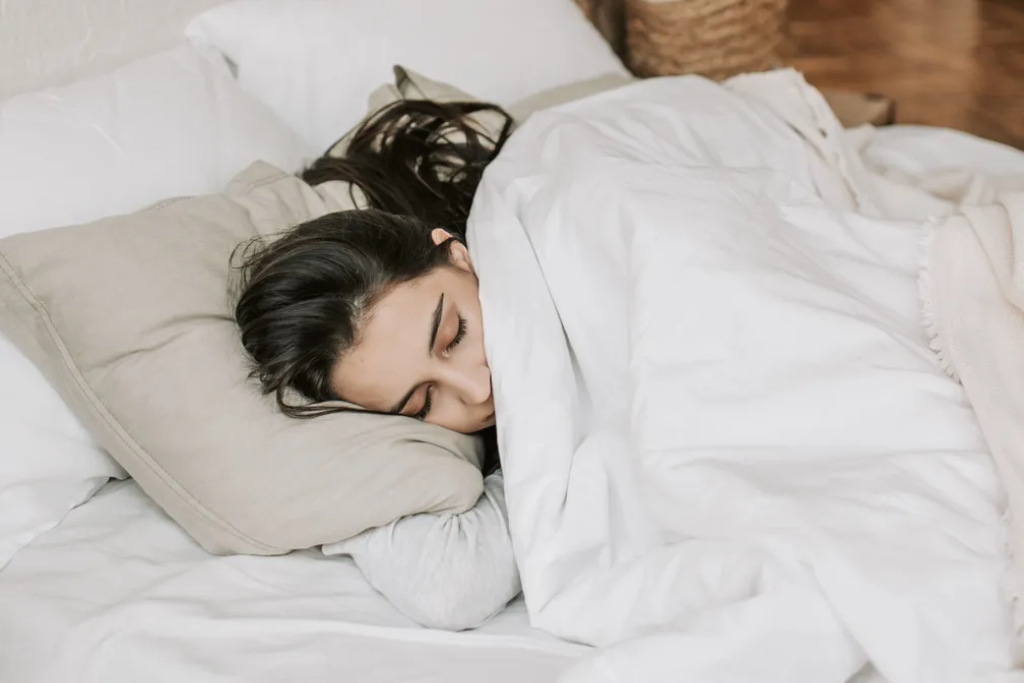 Mulher dormindo com persianas para melhorar o sono no inverno